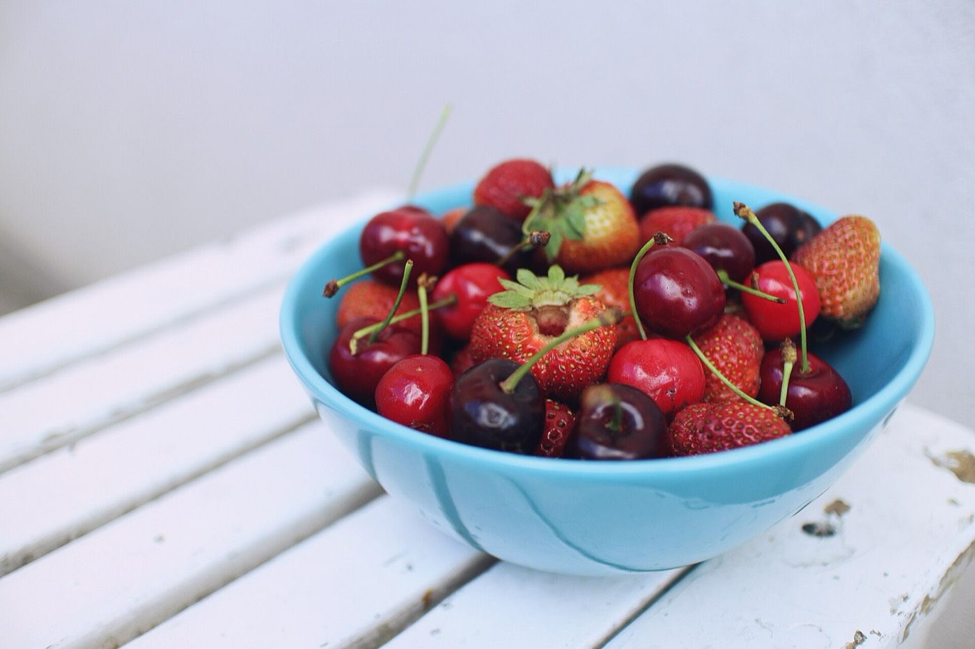 کاسه گیلاس و توت‌فرنگی تازه؛ مواد اولیه بستنی میوه‌ای طبیعی